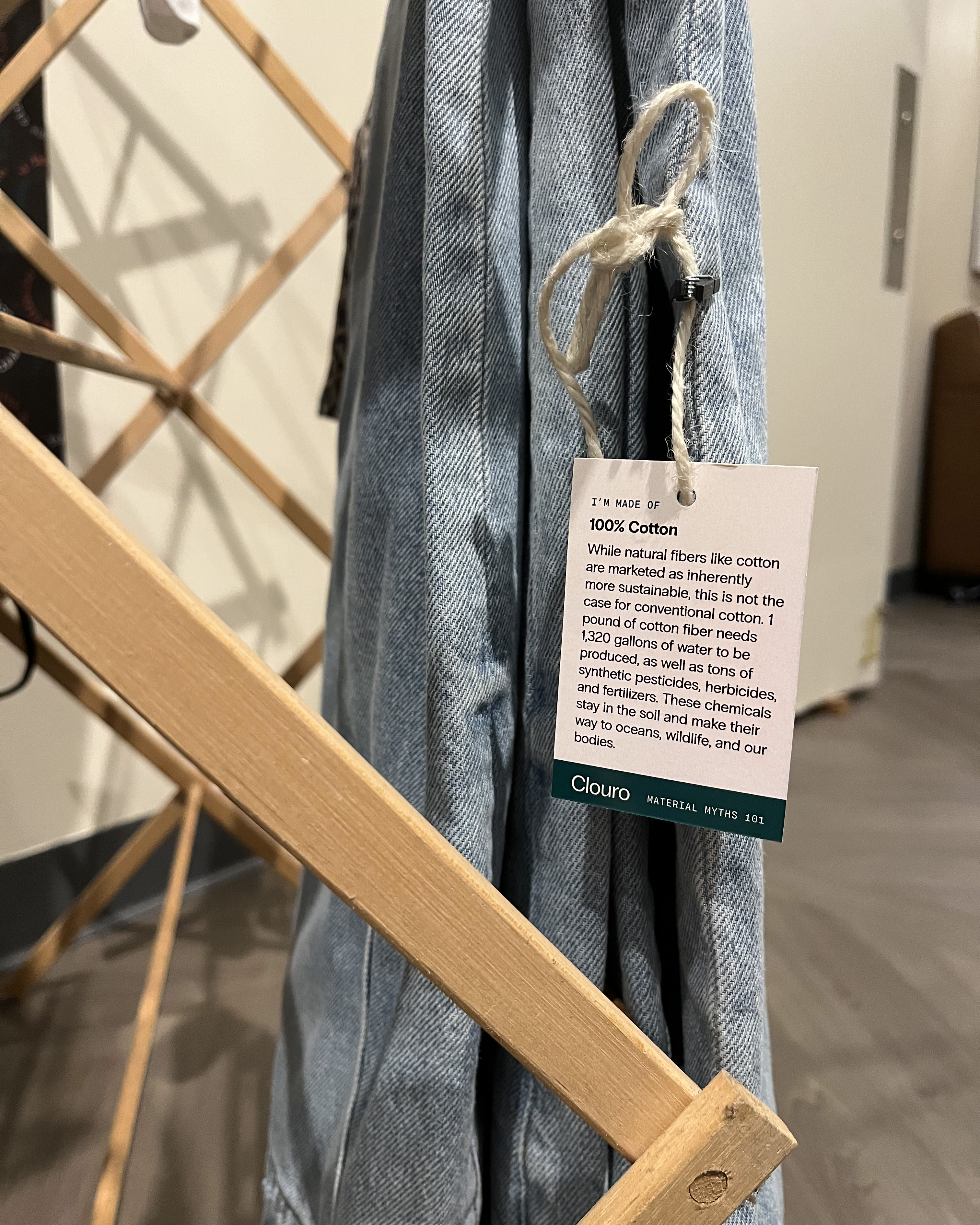clothing tag about organic cotton on jeans hanging from a clothing rack