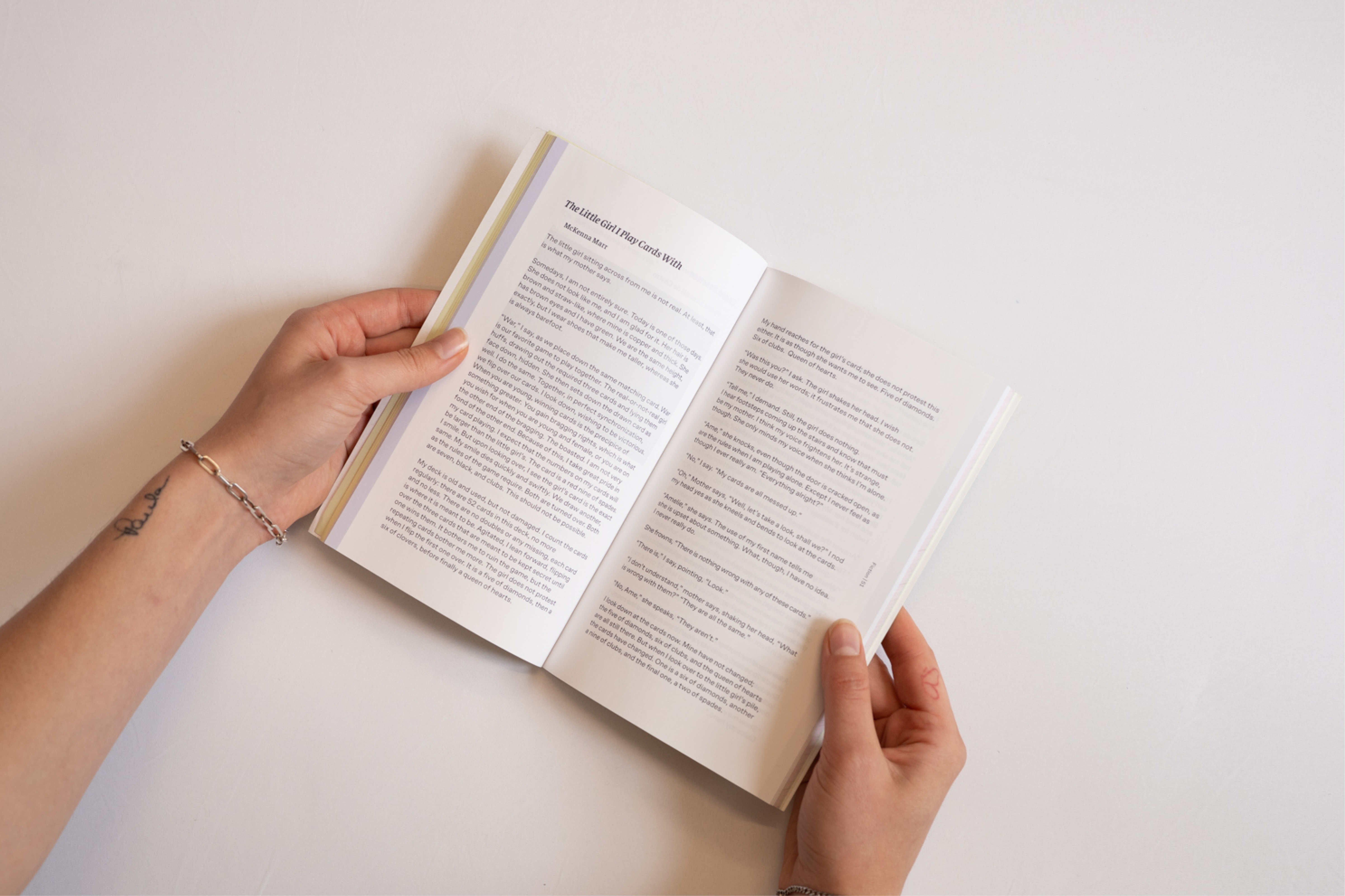 hands holding LRR book open to text spread